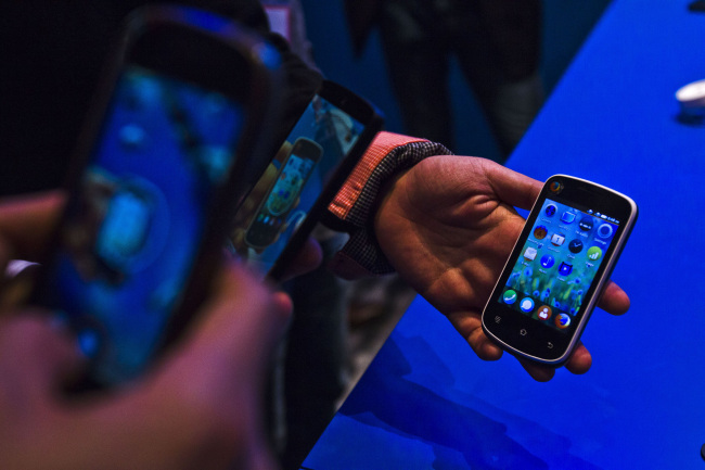 Attendees photograph an Alcatel Spreadtrum smartphone, which runs on the Firefox operating system, at the Mobile World Congress in Barcelona in February.   Bloomberg
