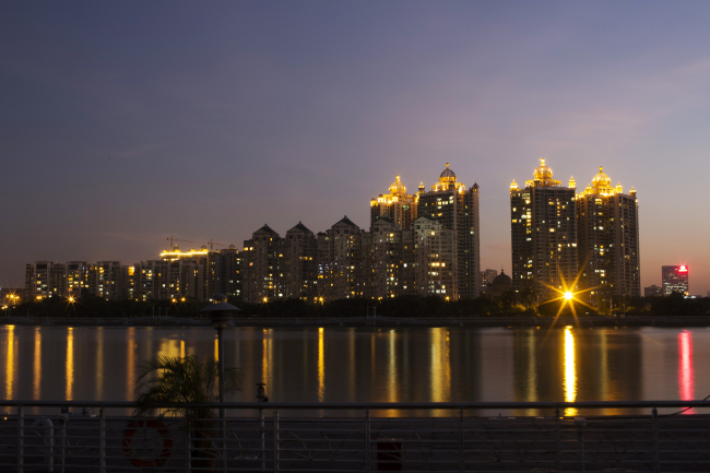 Residential apartment buildings are illuminated at night along the Zhujiang River in Guangzhou, Guangdong province, China.   Bloomberg