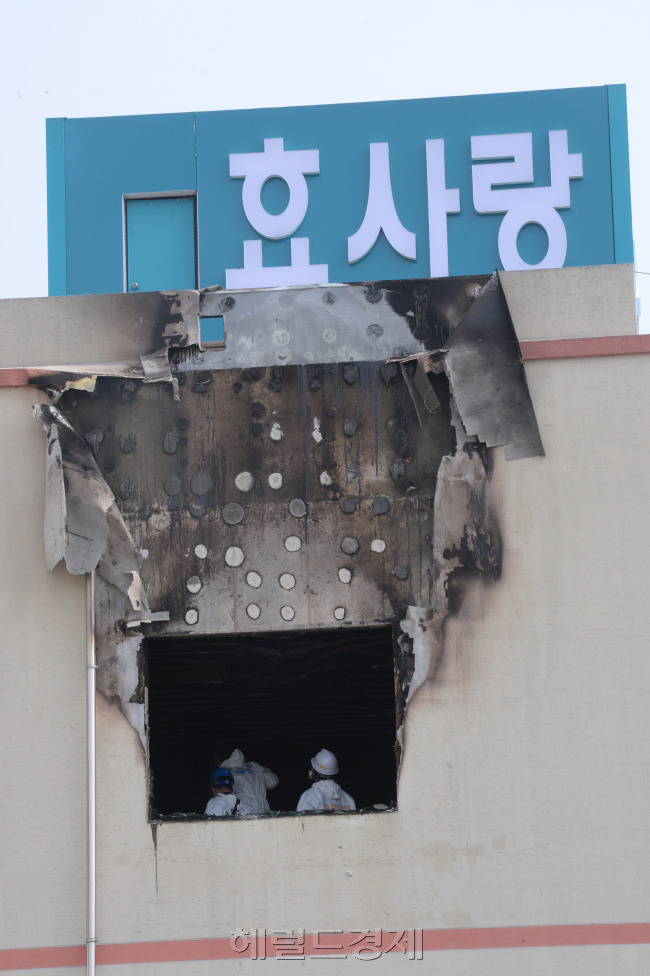 28일 오전 화재가 발생한 전남 장성군 삼계면 효사랑요양병원 별관 건물 2층에 국과수가 현장감식을 하고 있다. 다용도실에서 발생한 화재로  간호사 1명과 치매 노인 환자 등 21명이 숨지고 7명이 중경상을 입었다.  박현구 기자phko@heraldcorp.com 2014.05.28
28일 오전 화재가 발생한 전남 장성군 삼계면 효사랑요양병원 별관 건물 2층에 국과수가 현장감식을 하고 있다. 다용도실에서 발생한 화재로  간호사 1명과 치매 노인 환자 등 21명이 숨지고 7명이 중경상을 입었다.  박현구 기자phko@heraldcorp.com 2014.05.28
28일 오전 화재로 21명의 사망자가 발생한 전남 장성군 삼계면 효사랑요양병원 별관 건물 2층에 국과수가 현장감식을 하고 있다. 왼쪽부터 화재로 그을린 별관 외벽과 본관 유가족 대기실.  장성=박현구 기자/phko@