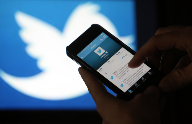 A user scrolls through a Twitter feed on the screen of an iPhone 5 in London.   Bloomberg