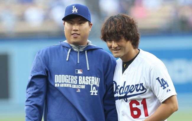 Los Angeles Dodgers pitcher Ryu Hyun-jin (left) and former Dodgers pitcher Park Chan-ho pose for photos after Park threw out the first pitch before the Dodgers-Reds game in Los Angeles on Tuesday.   AFP-Yonhap