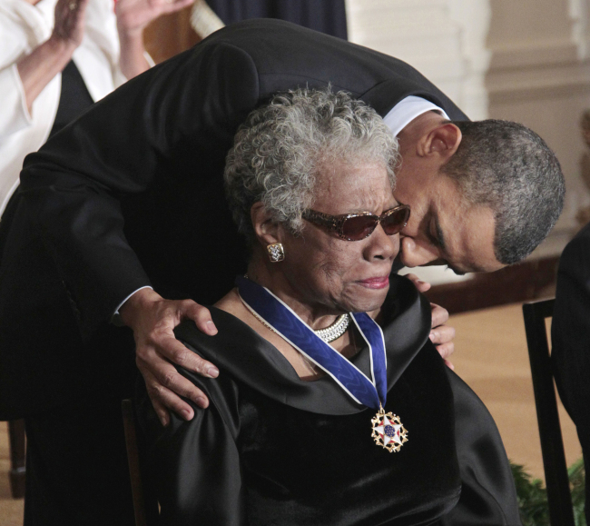 This Feb. 15, 2011 file photo shows President Barack Obama kissing author and poet Maya Angelou after awarding her the 2010 Medal of Freedom during a ceremony in the East Room of the White House in Washington.   AP-Yonhap