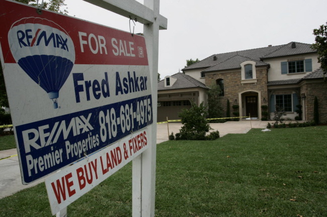 A “for sale” sign stands outside a home in Arcadia, California.   Bloomberg