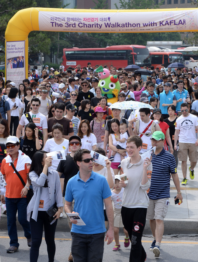 Participants in the third Charity Walkathon, organized by the Korean Association of Foreign Languages Academies, stroll the streets of Bukchon, a village in Seoul replete with traditional Korean houses, or hanok, Sunday. Proceeds from this year’s event, which drew over 1,000 participants, will go to a nursing college to be built in Nepal, organizers said.   Park Hyun-koo/The Korea Herald