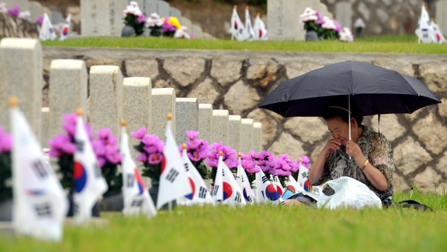 A family member prays at the National Cemetery in Seoul on Monday. The nation will commemorate Memorial Day on Friday.   Kim Myung-sub/The Korea Herald