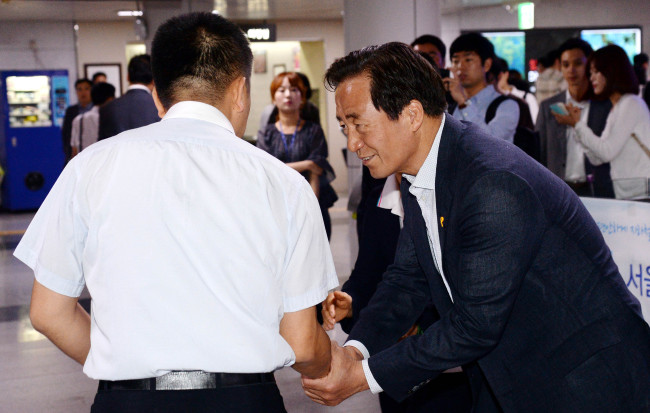 Saenuri Party Seoul mayor candidate Chung Mong-joon shakes hands with commuters in Seoul on Tuesday. (Ahn Hoon/The Korea Herald)
