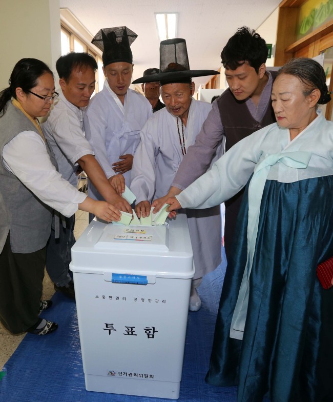 Voters wearing hanbok, traditional  garment, pose at the voting room in South Chungcheong Province, Wednesday.
