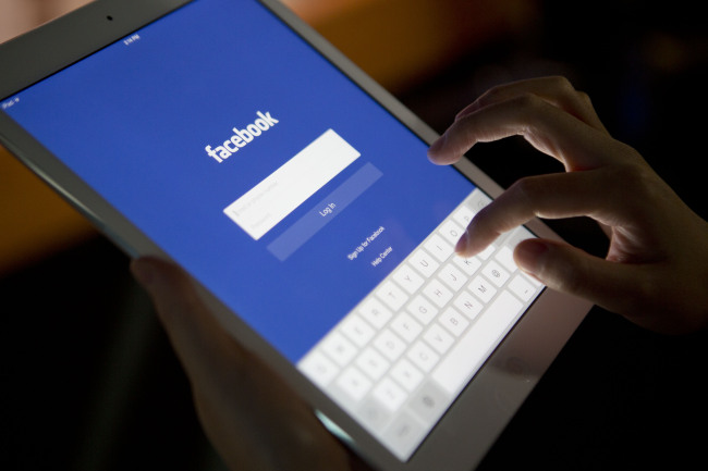 Facebook’s main application is demonstrated on an iPad Air in Washington, D.C.   Bloomberg