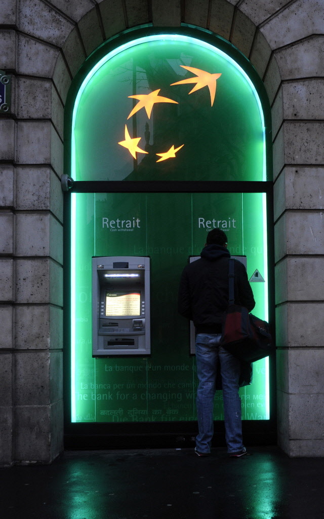 A customer uses an automated teller machine at a BNP Paribas bank branch in Paris.   Bloomberg