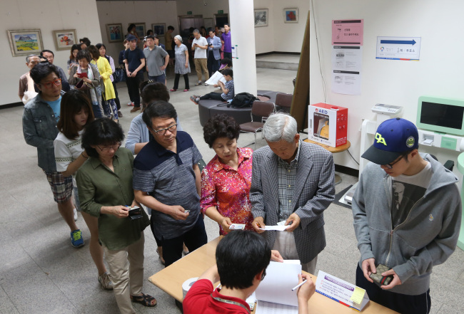 Voters line up to vote for the local elections in Seoul, Wednesday. (Yonhap)