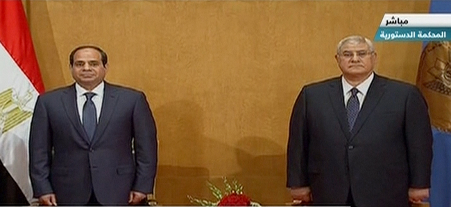 This image made from Egyptian State Television shows new President Abdel-Fattah el-Sissi (left) and outgoing interim President Adly Mansour at the Supreme Constitutional Court in Cairo on Sunday.   AP-Yonhap