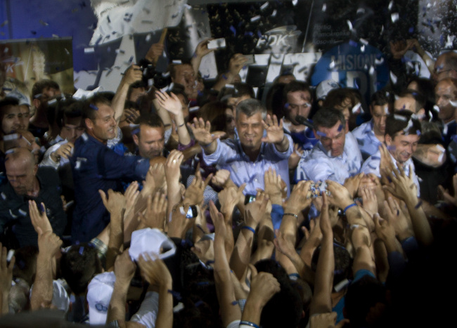 Kosovo’s Prime Minister Hashim Thaci (center) reaches out to supporters of the ruling Democratic Party of Kosovo celebrating preliminary election results in Kosovo’s capital Pristina on Sunday.   AP-Yonhap