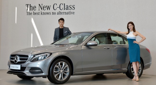 Models pose with the refashioned version of the Mercedes-Benz C-Class ― the fifth-generation of the German luxury carmaker’s best-selling sedan, at a media event held in Seoul on Monday.   Kim Myung-sub/The Korea Herald