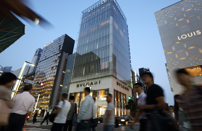 Pedestrians walk past a Tiffany & Co. store (left), Bulgari SpA store, a luxury unit of LVMH Moet Hennessy Louis Vuitton SA (center) and a Louis Vuitton store in the Ginza district of Tokyo.   Bloomberg