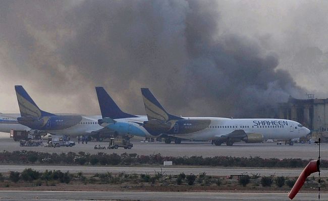 Smoke rises after militants launched an early morning assault at Jinnah International Airport in Karachi, Pakistan, Monday.   AFP-Yonhap
