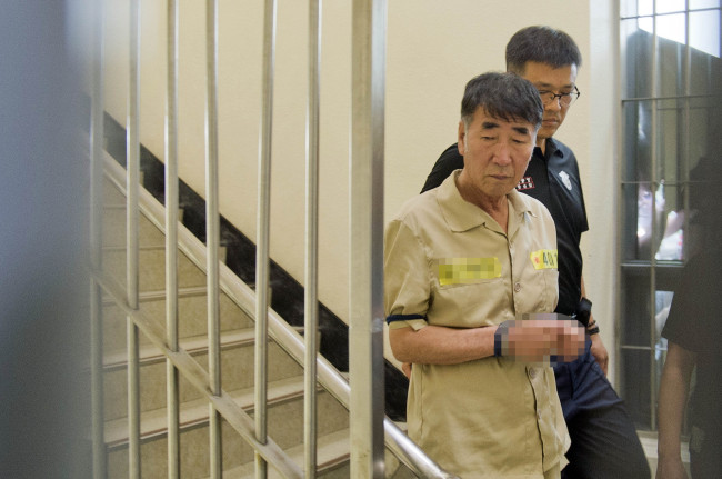 Lee Joon-seok, captain of the ill-fated ferry Sewol, is guided to a courtroom of the Gwangju District Court for a trial on Tuesday. Yonhap