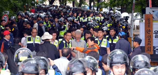 Policemen raid Geumsuwon in Anseong, Gyeonggi Province, on Wednesday in an attempt to arrest confidants of fugitive Yoo Byung-eun, the de facto owner of the ill-fated ferry Sewol on Wednesday.   Kim Myung-sub/The Korea Herald