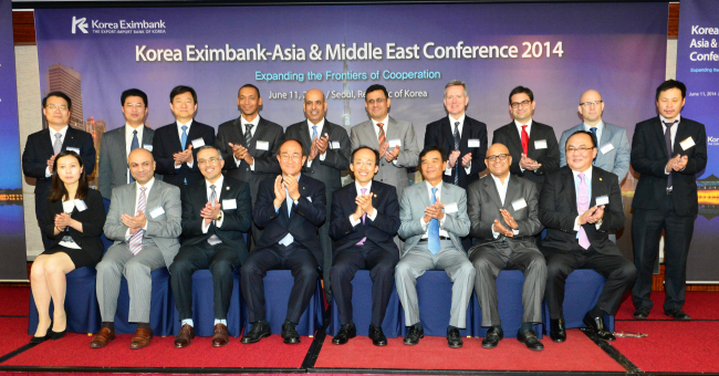 Export-Import Bank of Korea CEO Lee Duk-hoon (front row, fourth from left) poses with participants of the Korea Eximbank Asia & Middle East Conference 2014 including Vice Finance Minister Choo Kyung-ho (front row, fifth from left) and Vietnamese Vice Minister of Transport Truong Tan Vien (front row, third from right) on Wednesday.   Korea Eximbank