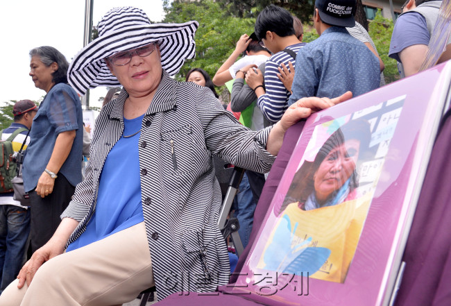 11일 오후 한국정신대문제대책협의회 주최로 서울 중학동에 위치한 일본대사관 앞에서 제1130차 일본군 위안부 문제 해결을 위한 정기 수요 시위가 열렸다. 위안부 피해자 이용수 할머니가 지난 8일 운명하신 위안부 피해자 배춘희 할머니의 영정을 손으로 쓰다듬고 있다.
