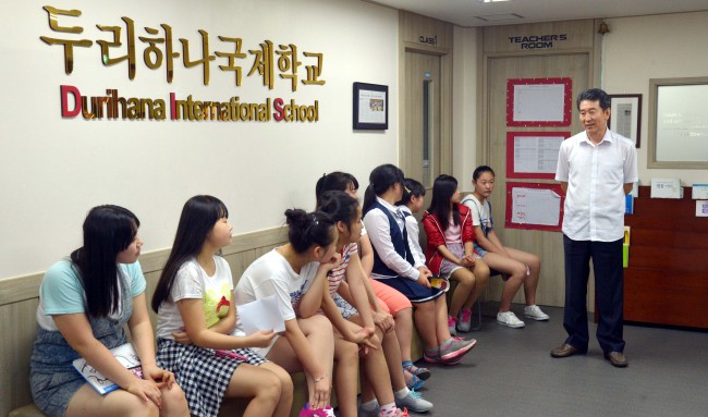 Students at the Durihana International School listen as their principal, Pastor Chun Ki-won (right), speaks on Tuesday. Kim Myung-sub/The Korea Herald