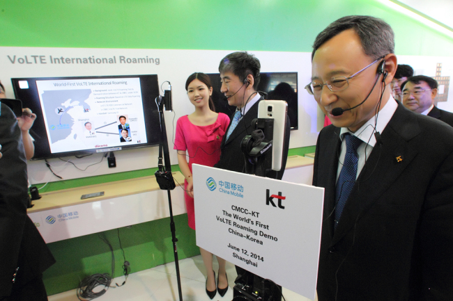 KT chief executive Hwang Chang-gyu (right) makes a “Voice over LTE” call with China Mobile chairman Xi Gouhua at the 2014 Mobile Asia Expo.   KT