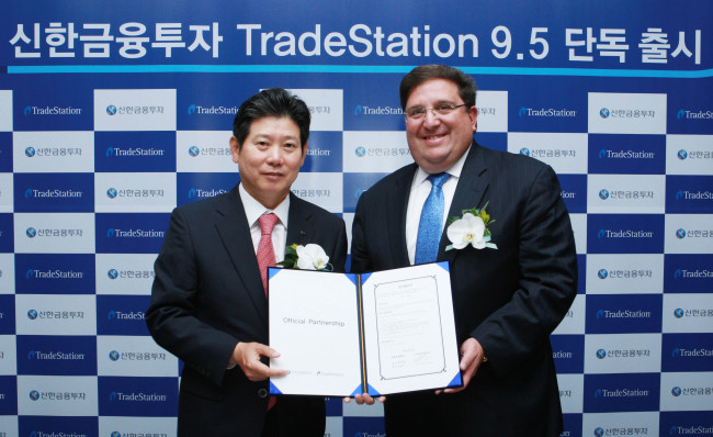 Shinhan Investment CEO Kang Dae-seok (left) and Salomon Sredni, CEO and chairman of TradeStation Group, celebrate the exclusive launch of TradeStation 9.5 in Korea on Thursday.    Shinhan Investment