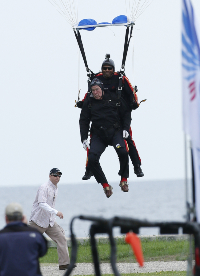<YONHAP PHOTO-0069> Former President George H.W. Bush, strapped to Sgt. 1st Class Mike Elliott, a retired member of the Army's Golden Knights parachute team, prepare to land on the lawn at St. Anne's Episcopal Church while celebrating Bush's 90th birthday in Kennebunkport, Maine, Thursday, June 12, 2014. (AP Photo/Robert F. Bukaty)/2014-06-13 01:07:47/ <저작권자 ⓒ 1980-2014 ㈜연합뉴스. 무단 전재 재배포 금지.>
Former U.S. President George H.W. Bush prepares to land on the lawn at St. Anne’s Episcopal Church while celebrating his 90th birthday in Kennebunkport, Maine, Thursday.      AP-Yonhap