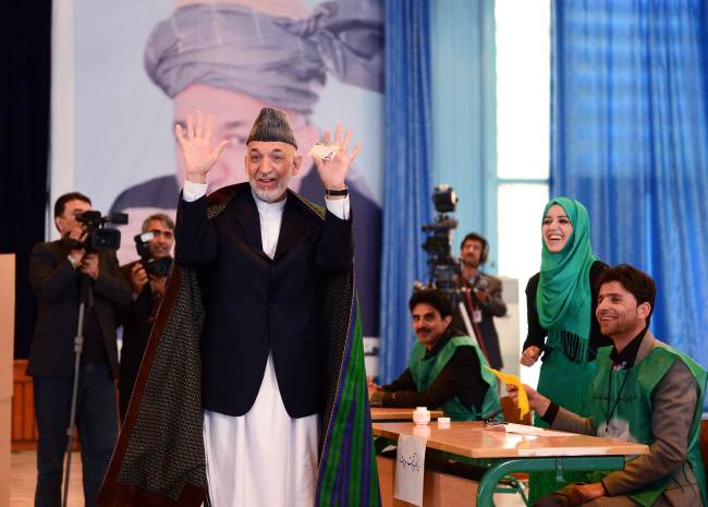 Afghan President Hamid Karzai holds up his voting card as he speaks to media while casting his ballot at a polling station in Kabul on Saturday.   AFP-Yonhap