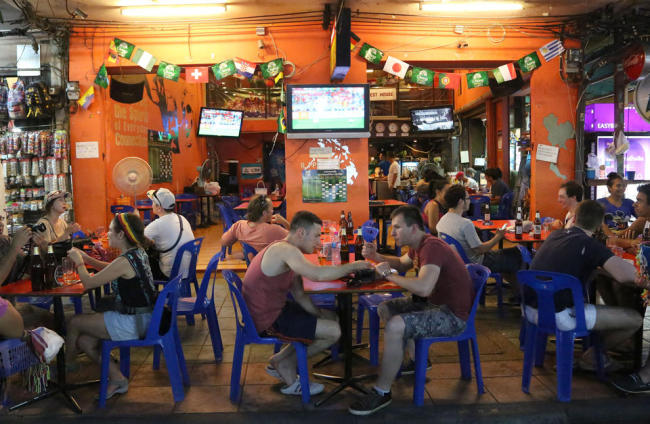 Tourists and locals eat and drink at a restaurant in Bangkok’s Khaosan road, Thailand, Saturday. The generals who seized power in Thailand have lifted a nationwide curfew, giving a green light for the capital’s red-light districts, nightclubs and pubs to roar back to life.   AP-Yonhap News