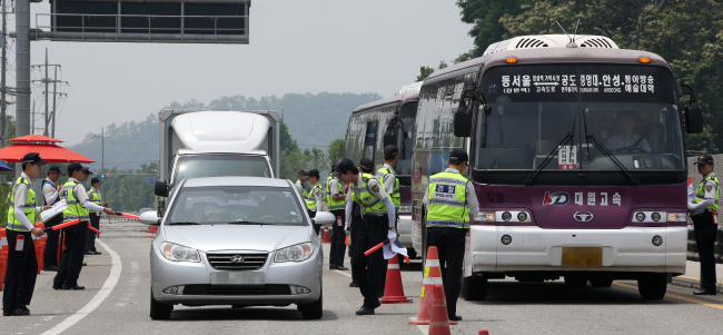Drivers are questioned by police officers on a street near Geumsuwon, a compound of the Salvation Sect, led by the fugitive Yoo Byung-eun, in Anseong, Gyeonggi Province. The prosecution has yet to arrest the owner of the sunken ferry Sewol despite a nationwide search for about four weeks.   Yonhap
