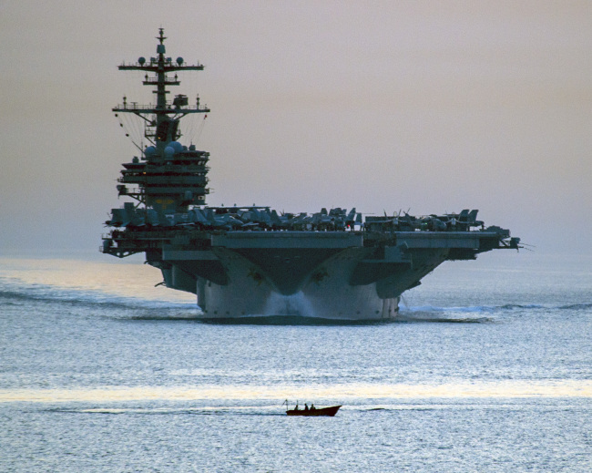 A small vessel passes in front of the U.S. Navy aircraft carrier the USS George H.W. Bush.   AP-Yonhap