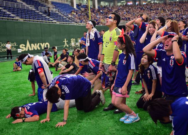 Japan’s football supporters, watching at the Tokyo Dome stadium in Tokyo on Sunday, are disappointed after Japan is defeated by Ivory Coast in the World Cup. Japan was defeated by Ivory Coast 1-2.AFP-Yonhap