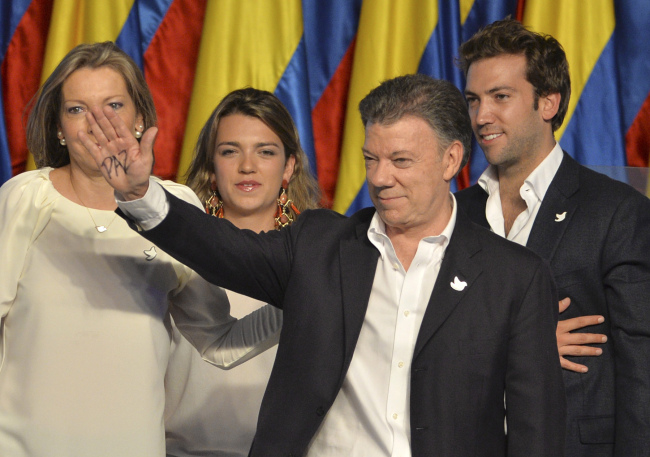 President Juan Manuel Santos waves during his victory rally next to first lady Maria Clemencia Rogriguez (left), his daughter Maria Antonia Santos and son Martin Santos at his campaign headquarters in Bogota, Colombia, Sunday.   AP-Yonhap