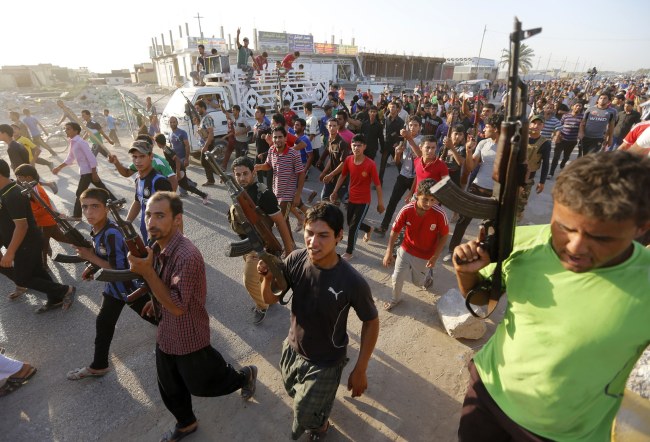 Volunteers, who have joined the Iraqi Army to fight against predominantly Sunni militants from the radical Islamic State of Iraq and the Levant, carry weapons during a parade in the streets in Al-Fdhiliya district, eastern Baghdad, Sunday.