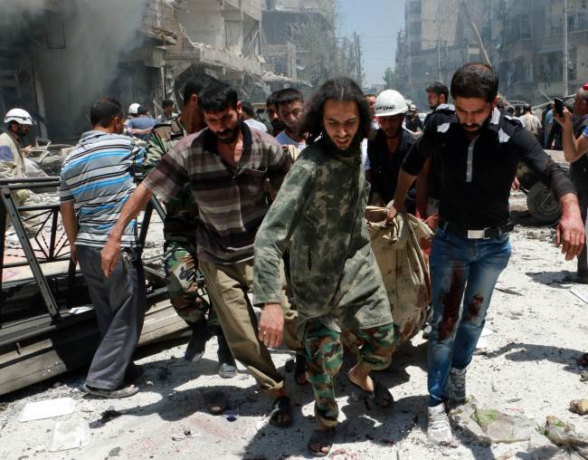 Rescuers carry a body after Syrian military helicopters dropped barrel bombs on the Sukkari neighborhood, an opposition-held district in the northern Syrian city of Aleppo, Monday.   AFP-Yonhap