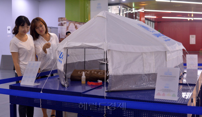세계 난민의 날 20일을 이틀 앞둔 18일 오전 서울시청 내 서울시민청에서 열린 유엔난민기구의 세계 난민의 날 전시 기념식에서 시민들이 전시된 전시품을 지켜보고 있다. 이번 전시회는 오는 20일까지 열린다