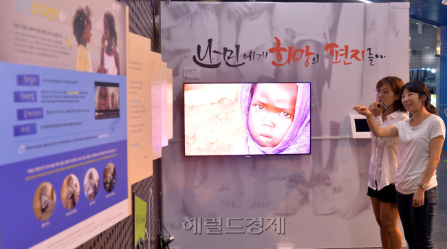 세계 난민의 날 20일을 이틀 앞둔 18일 오전 서울시청 내 서울시민청에서 열린 유엔난민기구의 세계 난민의 날 전시 기념식에서 시민들이 전시된 전시품을 지켜보고 있다. 이번 전시회는 오는 20일까지 열린다