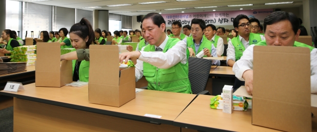 대우인터내셔널이 베이비박스에 버려지는 아이들을 지원하기 위한 ‘베이비 리본(Baby Re-born) 상자 만들기’ 캠페인을 실시했다고 19일 밝혔다.
대우인터내셔널은 전날 서울 본사 12층 대회의실에서 국제 NGO단체인 초록우산 어린이재단과 함께 아기용품이 담긴 선물상자를 만들었다. 전병일 사장을 비롯한 회사 임직원 200여명이 직접 바느질한 손싸개 및 아기용품으로 구성된 선물상자는 어린이재단과 연계된 서울ㆍ경기 지역 아동센터 7개소에 등록된 24개월 미만 아동 100여명에게 전달될 예정이다.
