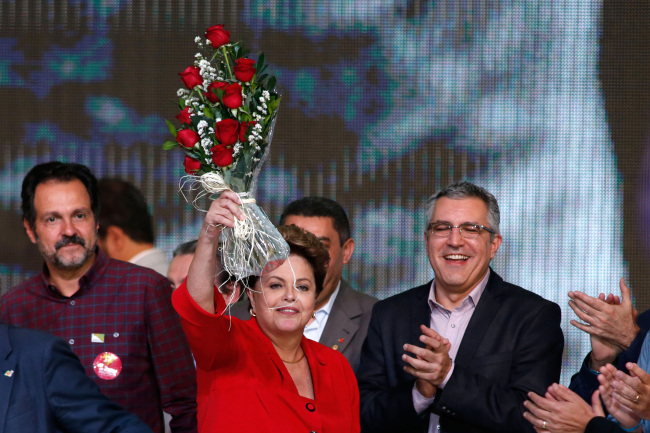 Brazil’s President Dilma Rousseff holds up roses she was given after being nominated as the presidential candidate at the Workers Party national convention in Brasilia on Saturday.   AP-Yonhap