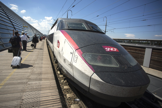 Passengers wait to board a TGV duplex high-speed train, operated by Societe Nationale des Chemins de Fer (SNCF) and manufactured by Alstom SA, as it stands in the railway station at Gare d'Avignon in Avignon, France, on Thursday, June 19, 2014. Siemens AG's plan had also envisioned merging the train operations of Siemens and Alstom and the Germany company said today it's now also offering an immediate rail-signaling joint venture with the French rival. Photographer: Balint Porneczi/Bloomberg
Passengers wait to board a TGV duplex high-speed train, manufactured by Alstom SA, in Avignon, France, Thursday.   Bloomberg