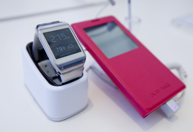 A Samsung Electronics Co. Galaxy Gear watch and Galaxy Note 3 sit on display during an event in Times Square, New York.   Bloomberg