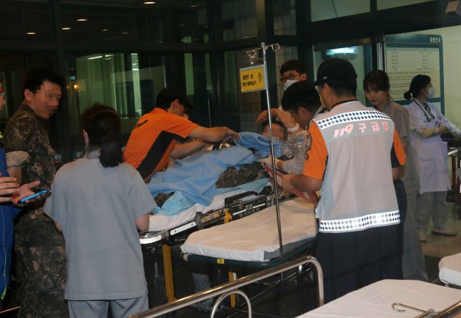 A wounded soldier is transported to a hospital in Gangneung, Gangwon Province on Saturday night after a shooting rampage in an eastern border unit. (Yonhap)