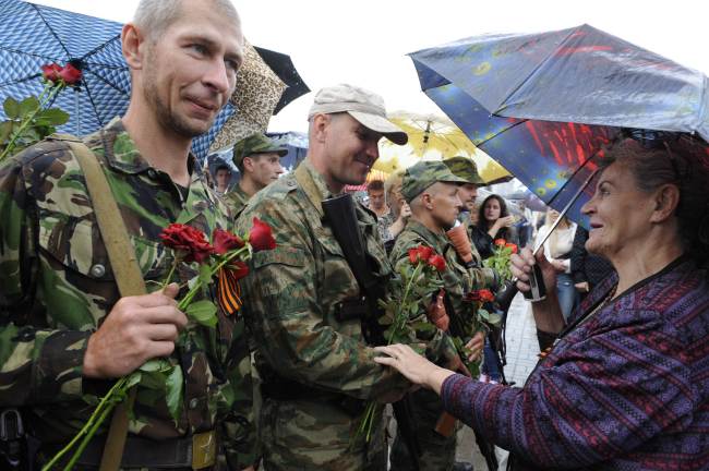 A woman speaks to pro-Russian militants as they take the military oath of allegiance to the People’s Republic of Donetsk during the ceremony in the eastern Ukrainian city of Donetsk on Saturday.   AFP-Yonhap