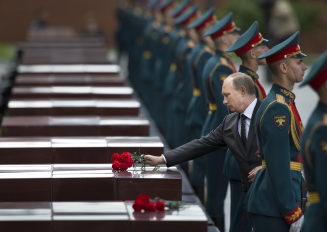 Russia’s President Vladimir Putin lays flowers during a ceremony to commemorate the anniversary of the beginning of the Great Patriotic War against Nazi Germany in 1941 near memorials by the Kremlin walls in Moscow on Sunday. He publicly expressed support for Ukraine’s declaration of a cease-fire in its battle against pro-Russian separatists and called on both sides to negotiate a compromise. (Related story on Page 6)   AP-Yonhap