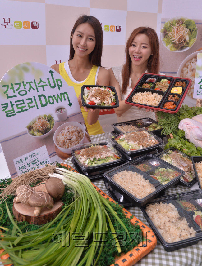 한식 도시락 브랜드 본도시락이 24일 오전 서울 종로구 청계천로에서 더운 여름을 앞두고 칼로리는 낮추고 건강지수는 높인 보양 도시락 신메뉴 ‘전복삼계밥 도시락’과 ‘삼채 닭가슴살 샐러드’의 출시 행사를 가졌다.