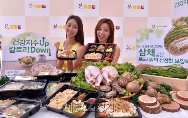 한식 도시락 브랜드 본도시락이 24일 오전 서울 종로구 청계천로에서 더운 여름을 앞두고 칼로리는 낮추고 건강지수는 높인 보양 도시락 신메뉴 ‘전복삼계밥 도시락’과 ‘삼채 닭가슴살 샐러드’의 출시 행사를 가졌다.