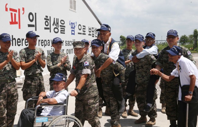 6.25 전쟁 64주년을 하루 앞둔 24일(현지시간) 필리핀 레이테주 타크로반시 아라우부대에서 한국전 참사용사 초청 행사가 열렸다. 태풍 피해 복구와 재건업무를 띠고 현지에 파견된 아라우부대 한국군 장병들이 행사가 끝난 뒤 참전용사들과 함께 이동하고 있다.  필리핀이 파병한 7,420명 중 레이테주에서는 8명 참전했고 현재 4명(앞줄 왼쪽부터)그레솔라(휠체어.84),테베스(85),로브리고(85),라가스(88)등이 생존해 있다.<br />행사가 열린 강당 벽면에 "피의 희생을 땀으로 보답한다"가 적혀 있다.<br />사진공동취재단
6.25 전쟁 64주년을 하루 앞둔 24일(현지시간) 필리핀 레이테주 타크로반시 아라우부대에서 한국전 참사용사 초청 행사가 열렸다. 태풍 피해 복구와 재건업무를 띠고 현지에 파견된 아라우부대 한국군 장병들이 행사가 끝난 뒤 참전용사들과 함께 이동하고 있다.  필리핀이 파병한 7,420명 중 레이테주에서는 8명 참전했고 현재 4명(앞줄 왼쪽부터)그레솔라(휠체어.84),테베스(85),로브리고(85),라가스(88)등이 생존해 있다.
행사가 열린 강당 벽면에 "피의 희생을 땀으로 보답한다"가 적혀 있다.
사진공동취재단