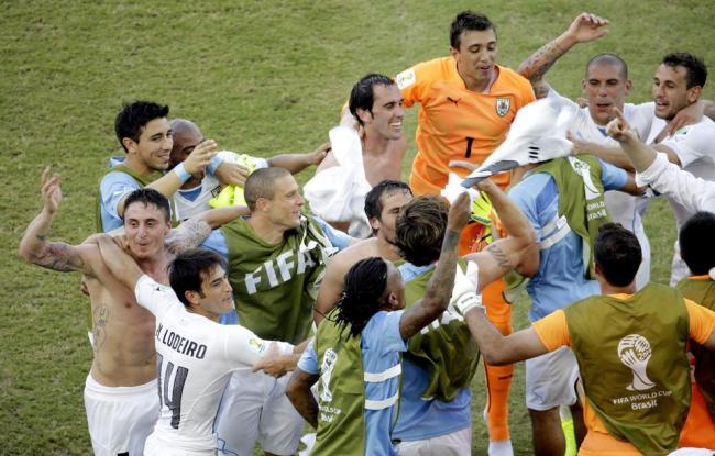 Uruguay players celebrate after defeating Italy 1-0 during the group D World Cup soccer match between Italy and Uruguay at the Arena das Dunas in Natal, Brazil, Tuesday. (AP)