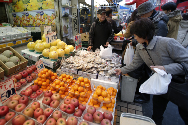 Customers shop for dried sweet potatoes at a market in the Ueno district of Tokyo.   Bloomberg