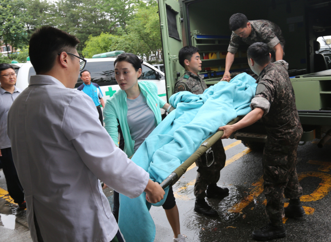 Medical staff move a soldier posing as the sergeant who was captured after a shooting spree last week to an emergency center at a hospital in Gangneung, Gangwon Province, Monday.   Yonhap